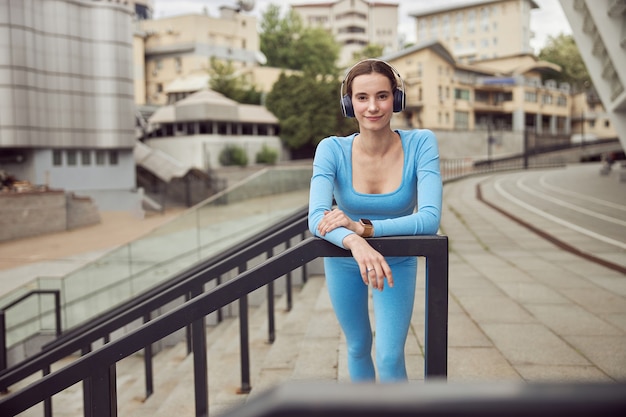 Uma jovem em forma está fazendo exercícios e correndo em um local urbano