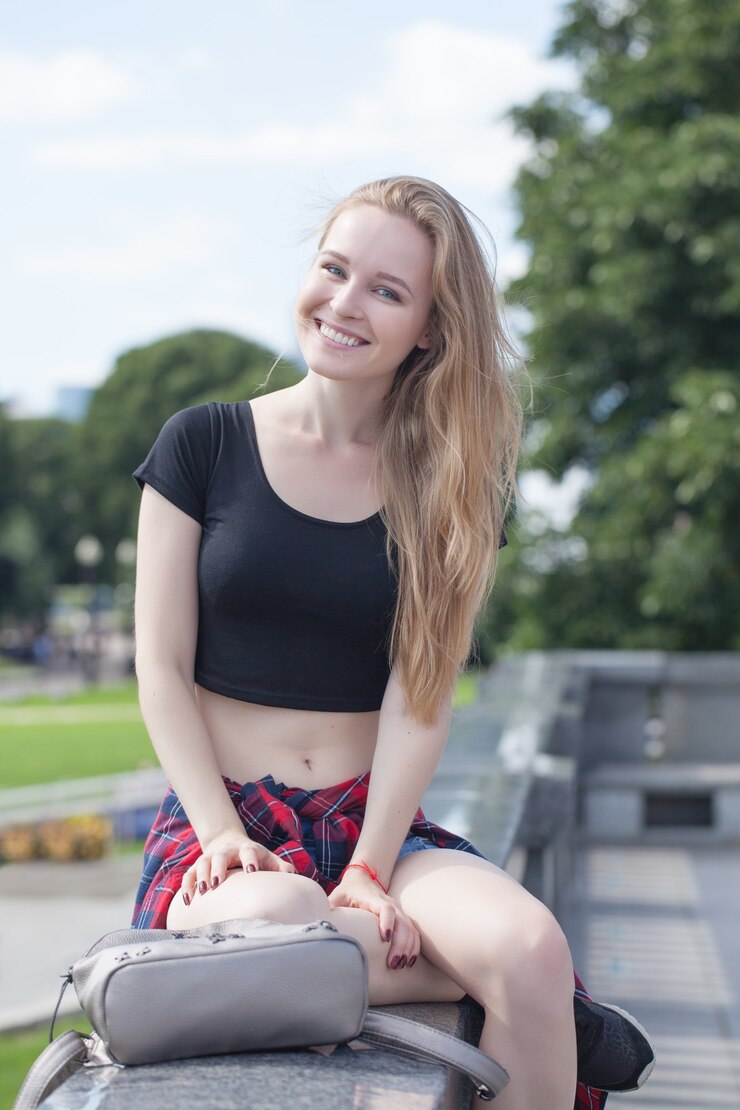 Foto uma jovem em shorts e um tópico preto na cidade. emoções brilhantes, estilo de vida, dia ensolarado