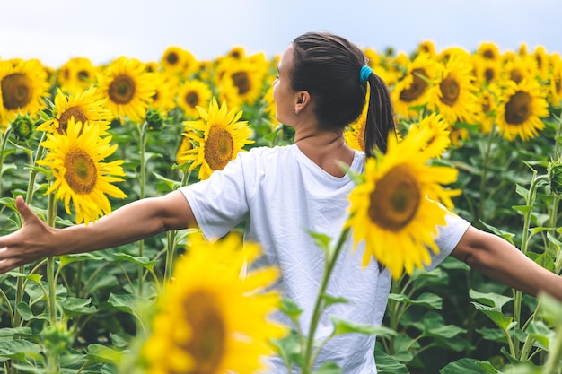 Uma jovem em um campo com muitos girassóis