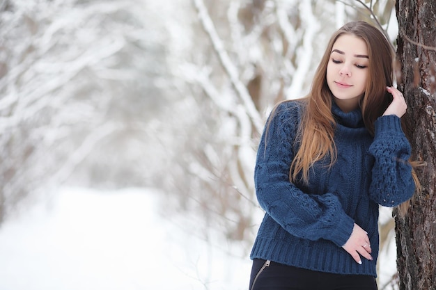 Uma jovem em um parque de inverno em uma caminhada férias de Natal na floresta de inverno A garota gosta de inverno no parque