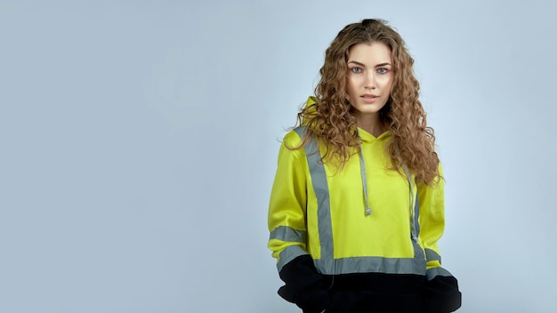 Uma jovem em um uniforme de trabalho em um fundo cinza