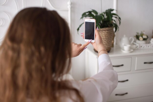 Uma jovem emocional pressiona o botão do telefone sem rosto