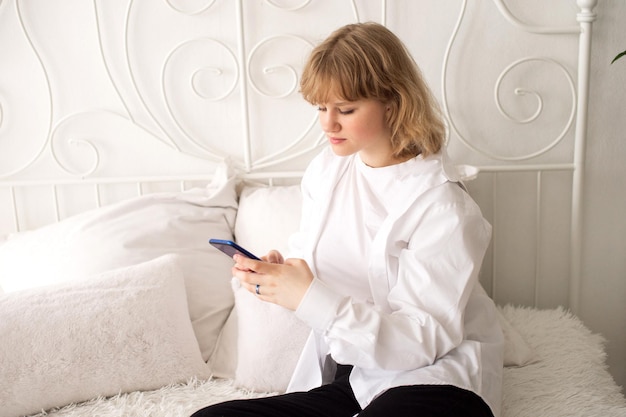 Uma jovem empresária lê as notícias ou envia uma mensagem de texto