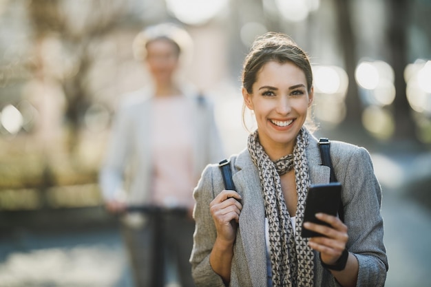 Uma jovem empresária usando smartphone enquanto vai trabalhar.