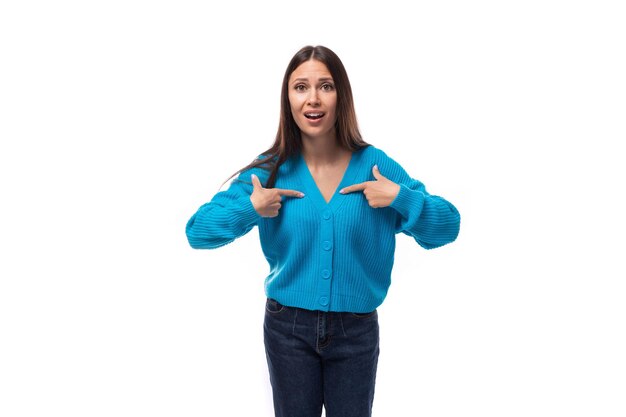 Foto uma jovem encantadora e bonita vestida com um suéter azul sentindo-se feliz