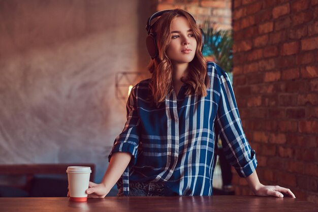 Uma jovem encantadora sensual ouvindo uma música em fones de ouvido