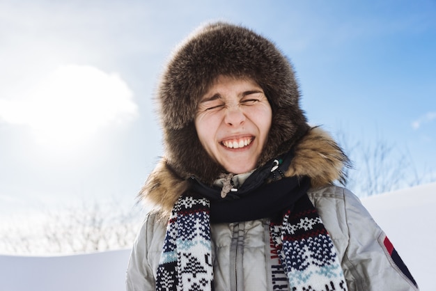 Uma jovem engraçada com um chapéu de pele quente está viajando pela Islândia. Está muito frio