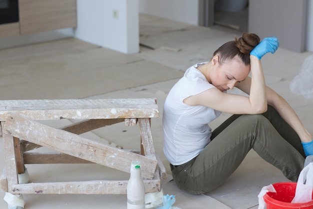 Uma jovem entre 30 e 40 anos está reformando apartamento.