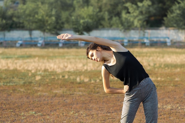 Uma jovem esbelta atlética em roupas esportivas com estampas de pele de cobra realiza um conjunto de exercícios Descansando após a prática de ioga