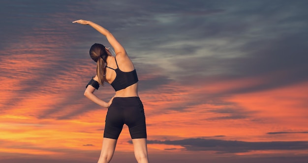 Uma jovem esbelta atlética em roupas esportivas com estampas de pele de cobra realiza um conjunto de exercícios