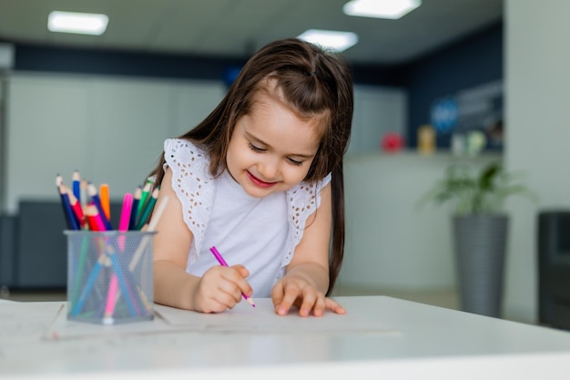 Uma jovem escreve em um papel com um lápis.