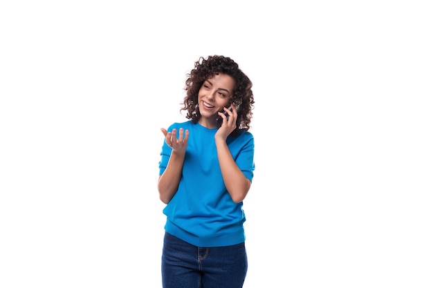 Uma jovem esguia esguia vestida com uma jaqueta de verão azul fala ao telefone