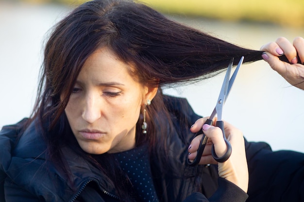 Uma jovem está a cortar o cabelo, um ato de protesto.