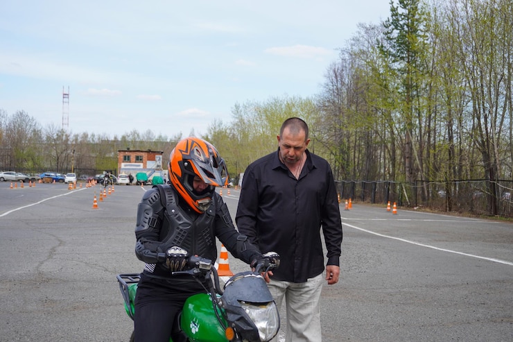 Foto uma jovem está aprendendo a andar de moto em uma escola de motocicleta ela é ensinada por um professor