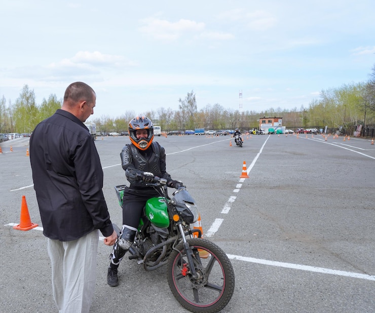 Foto uma jovem está aprendendo a andar de moto em uma escola de motocicleta ela é ensinada por um professor