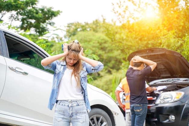 Foto uma jovem está chateada com um acidente de carro no fundo de uma estrada de campo brilhante