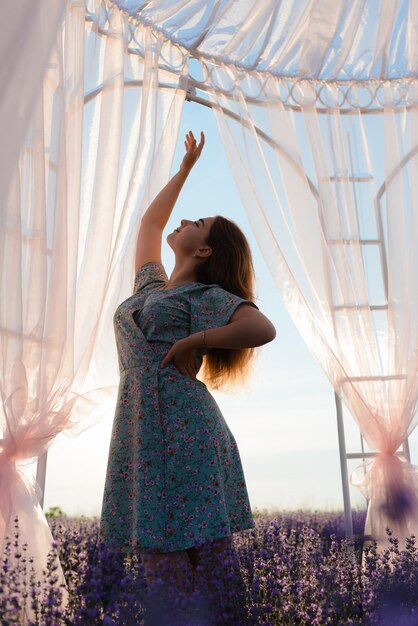 Foto uma jovem está dançando em um campo de lavanda ao nascer do sol