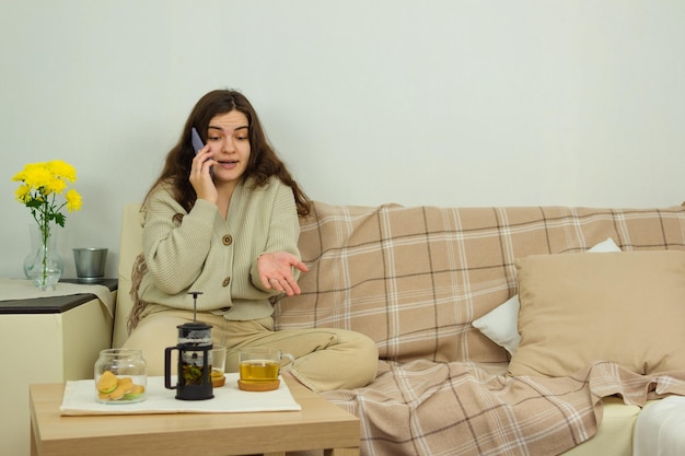 Uma jovem está emocionalmente falando em um celular indignado gesticulando com as mãos