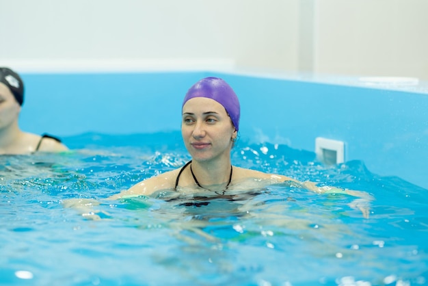 Uma jovem está envolvida em aqua yoga na piscina Natação para mulheres grávidas Conceitos de saúde