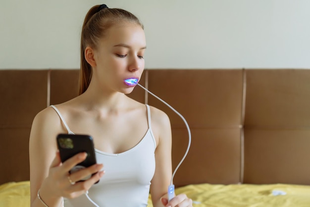 Uma jovem está envolvida em branqueamento de dentes em casa