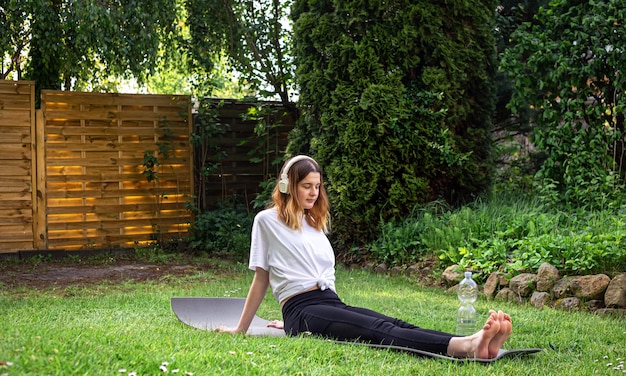 Uma jovem está envolvida em fitness na natureza em um tapete