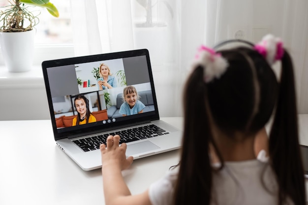 Uma jovem está frequentando uma escola ou aulas on-line. Estude em confinamento porque as escolas fecharam devido à Covid-19. Papel da tecnologia durante o bloqueio nacional. Conceito de aprendizagem em casa.