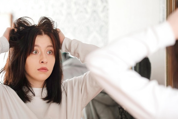 Uma jovem está muito chateada e surpresa com a condição de seu cabelo