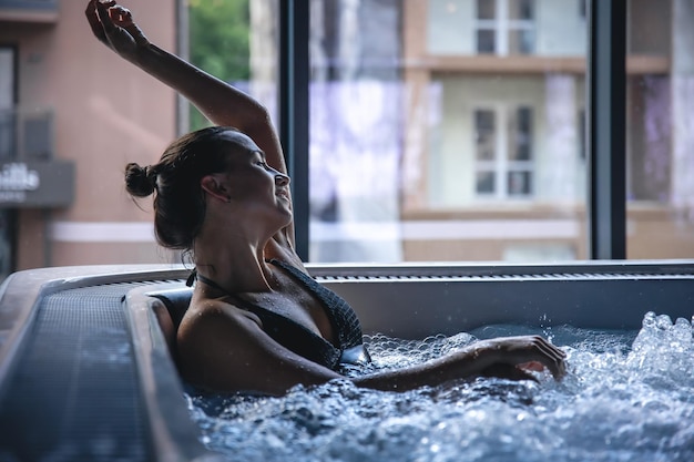 Uma jovem está relaxando em uma jacuzzi