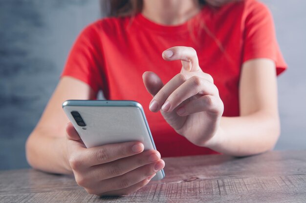 Uma jovem está sentada com um telefone