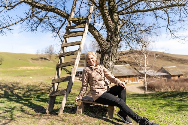 Uma jovem estava sentada contra um tronco de árvore em um campo.