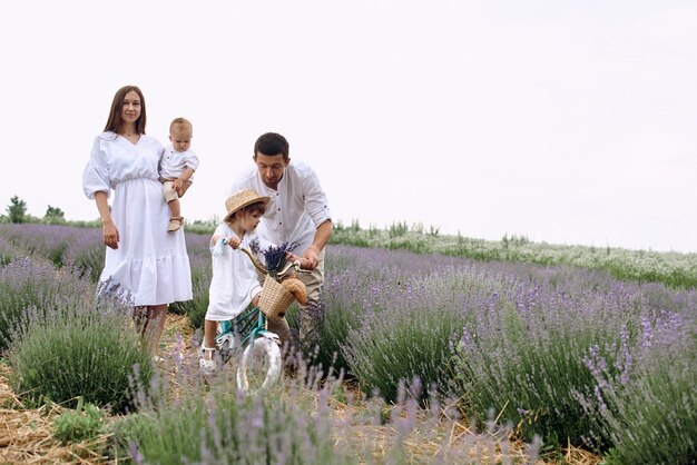 Uma jovem família caminha com seus filhos em um campo de lavanda.