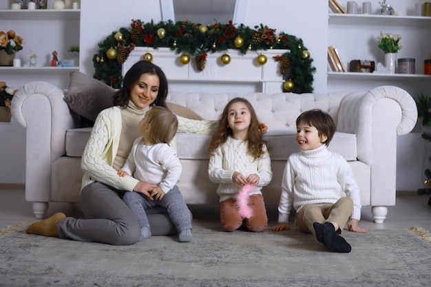 Uma jovem família com filhos decora a casa para o feriado. Véspera de Ano Novo. Esperando pelo novo ano.