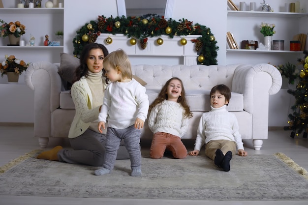 Uma jovem família com filhos decora a casa para o feriado. Véspera de Ano Novo. Esperando pelo novo ano.