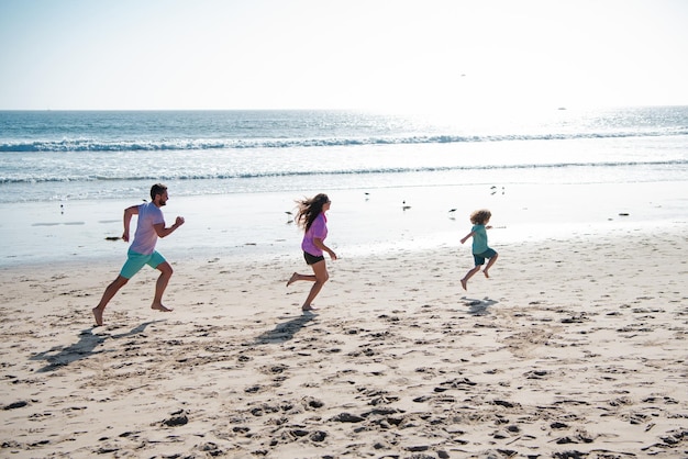 Uma jovem família feliz corre e salta no conceito de praia de verão de família amigável e de férias de verão ch