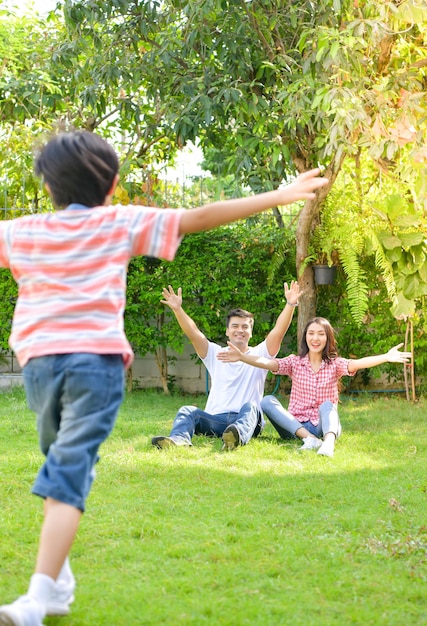 Uma jovem família feliz passa o tempo brincando juntos no jardim na frente da casa as férias