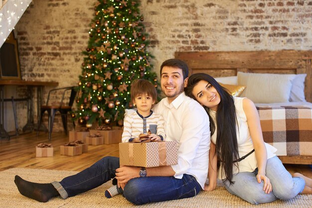 Uma jovem família no apartamento decorado para o Natal