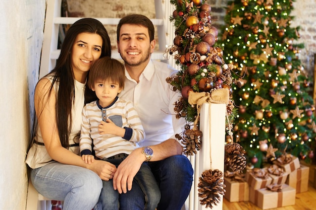 Uma jovem família no apartamento decorado para o natal