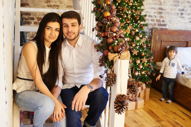 Uma jovem família no apartamento decorado para o Natal