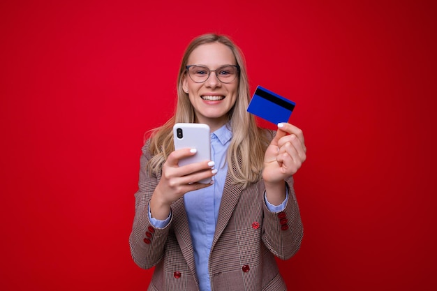 Uma jovem faz compras online em um fundo vermelho