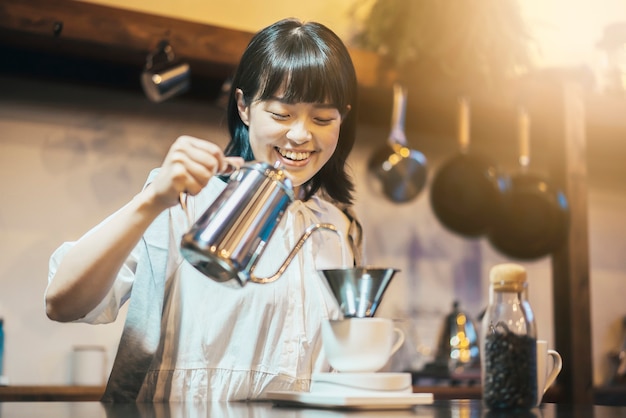 Uma jovem fazendo café com gotejamento em um espaço bem iluminado