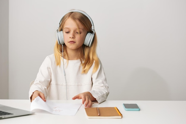 Uma jovem feliz a usar um portátil para aprendizagem eletrónica e jogos online em casa, melhorando a sua educação e