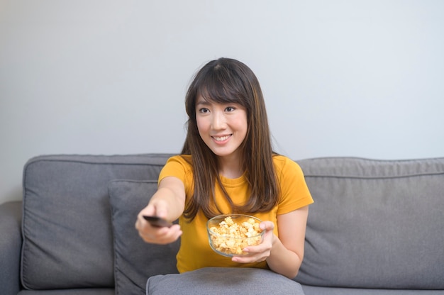 Uma jovem feliz assistindo filme e relaxando em casa