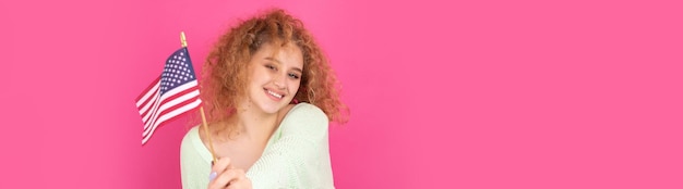 Uma jovem feliz com um sorriso no rosto segura uma bandeira americana em suas mãos Símbolo de patriotismo e liberdade