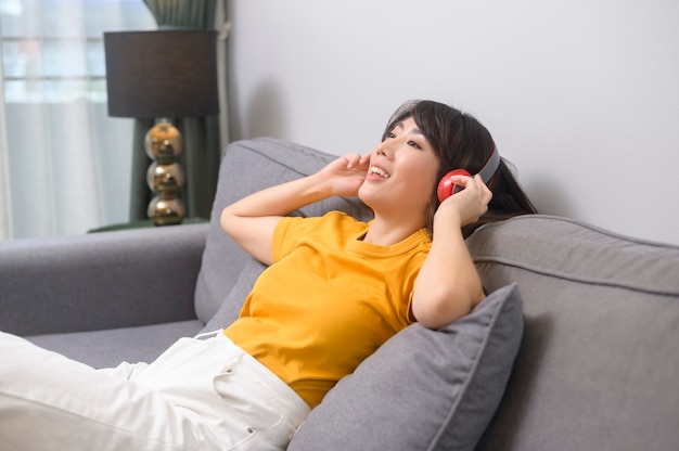 Uma jovem feliz ouvindo música e relaxando em casa