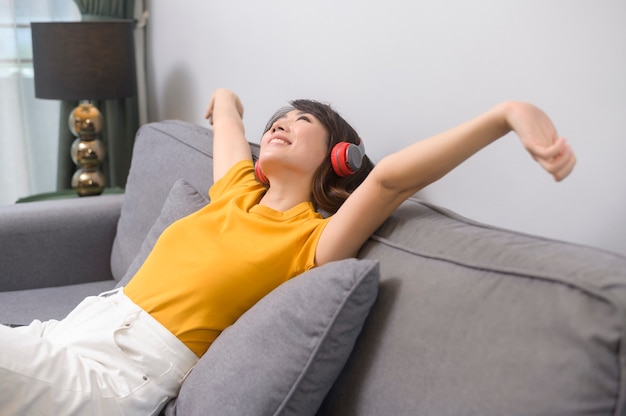 Uma jovem feliz ouvindo música e relaxando em casa