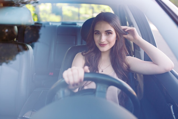 Uma jovem garota está dirigindo um carro.