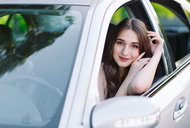 Uma jovem garota está dirigindo um carro.