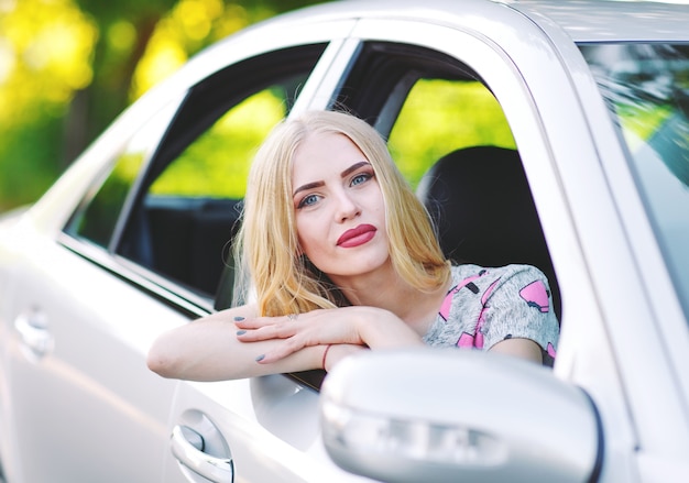 Uma jovem garota está dirigindo um carro.