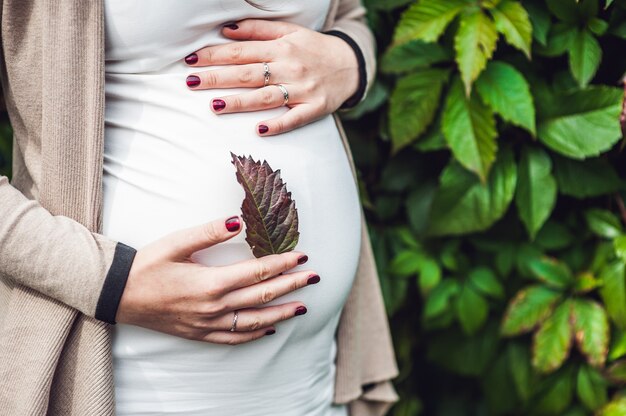 Uma jovem grávida segurando a barriga.