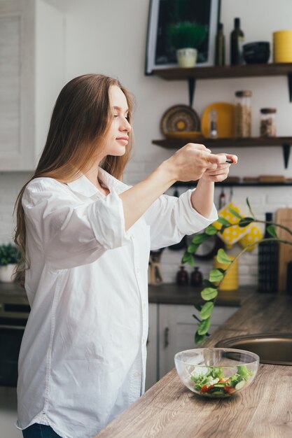 Uma jovem grávida tira fotos de uma salada preparada em seu smartphone